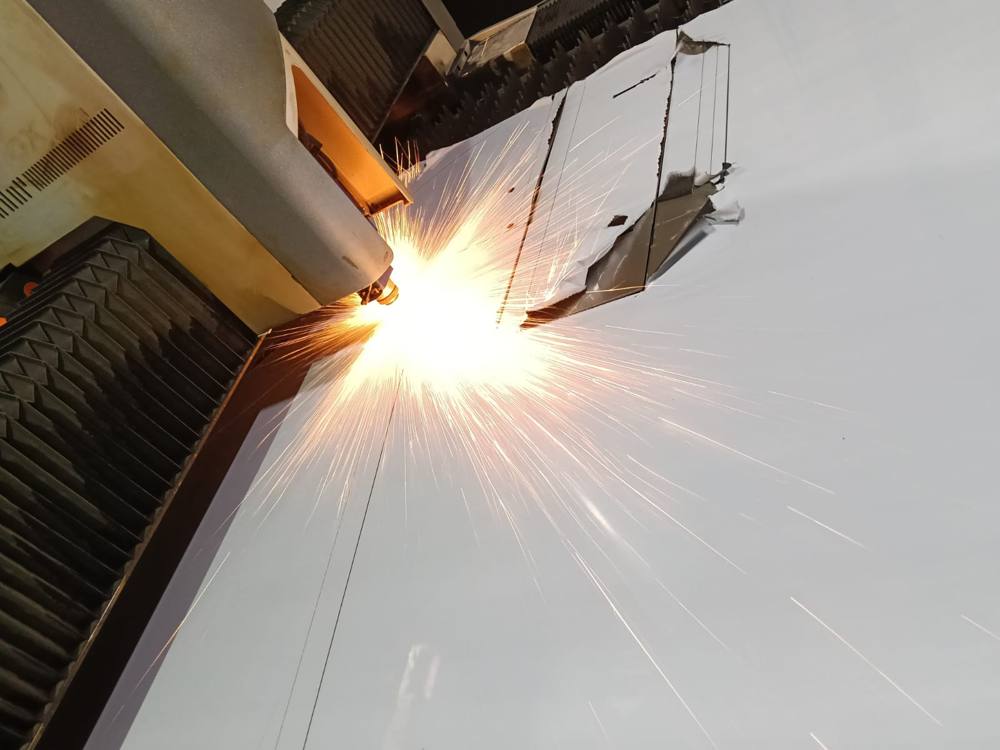 Corte láser con chispas sobre plancha metálica